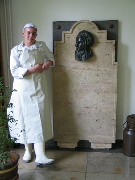 Auszubildender Molkereifachmann der MLUA Krefeld in Arbeitskleidung vor dem ersten Käsedenkmal der Welt